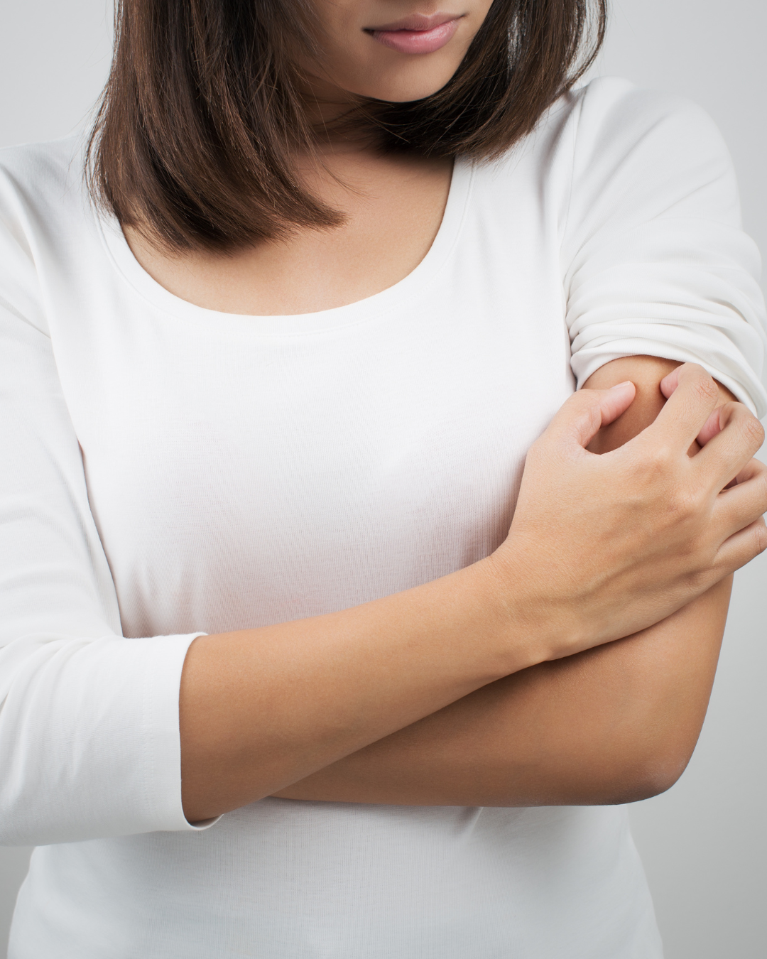 A woman examining a summer skin rash or bug bite.