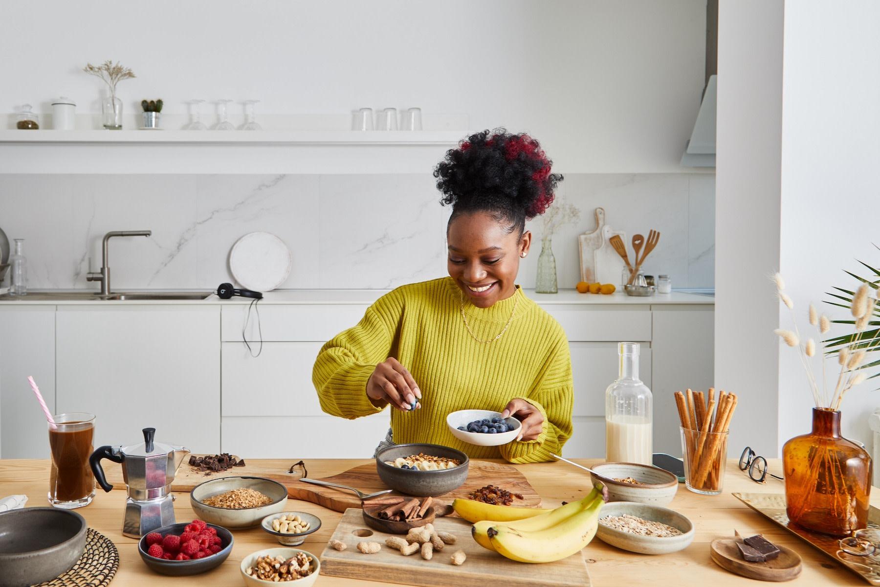 Woman preparing a healthy breakfast with fresh fruit as part of a lifestyle to help prevent type 2 diabetes.