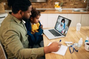 Parent and child having a virtual urgent care visit from home for sore throat symptoms.